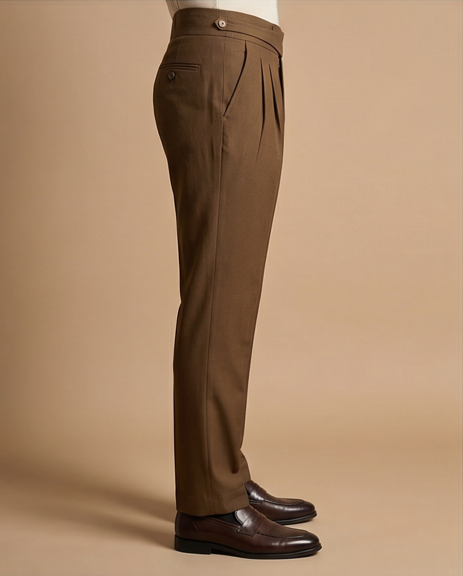 Brown dress pants worn by a person on a beige background